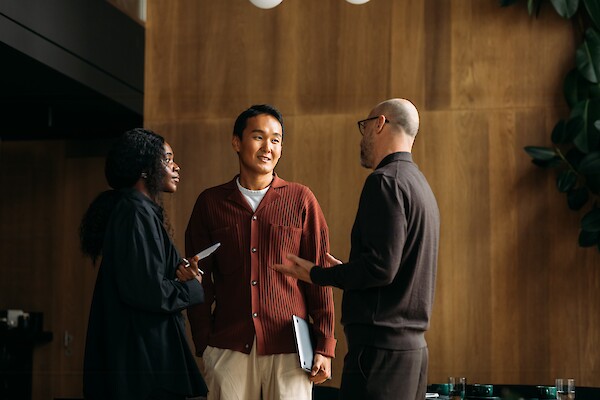 Diverse professionals collaborate in a modern, wood-paneled tenant amenity space at 260 Madison Avenue, an office building in Midtown Manhattan.