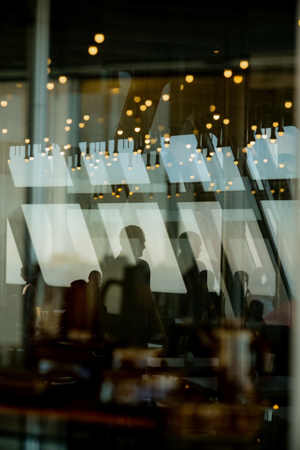 Artistic, blurred interior view of a modern cafe or social lounge at 260 Madison Avenue, capturing the warm lighting and collaborative energy of the tenant amenity spaces.